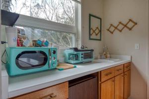 a kitchen with a blue microwave on a counter at #StayinMyDistrict Cape Arago Ocean Studio Suite in Coos Bay