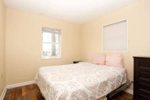 Un dormitorio con una cama con almohadas rosas y una ventana en Best Deal in Knoxville, en Knoxville