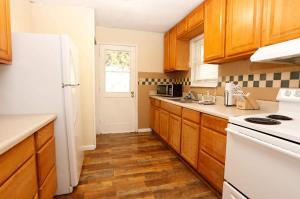 eine Küche mit Holzschränken und einem weißen Kühlschrank in der Unterkunft Best Deal in Knoxville in Knoxville