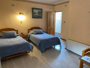 Habitación de hotel con 2 camas y pasillo en Hotel Libertador Bernardo O´Higgins, en Chillán