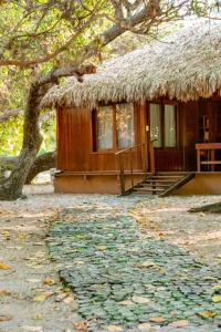 uma pequena cabana com um telhado de relva e um caminho em Refugios Parajuru - Pavilhão em Parajuru