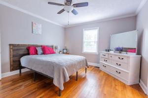 a bedroom with a bed and a dresser and a ceiling fan at Single Family Home in Rossville GA! in Rossville