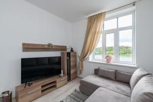 a living room with a couch and a flat screen tv at Serene Nemunas River View apartment near McDonald by Polo Apartments in Kaunas