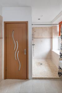 a bathroom with a shower and a wooden door at Serene Nemunas River View apartment near McDonald by Polo Apartments in Kaunas