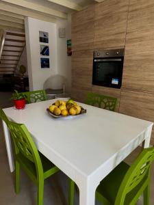 una mesa blanca con un plato de fruta. en Messapia, la casa fra i due mari, en Cellino San Marco