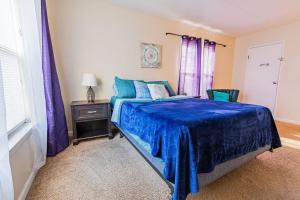 a bedroom with a blue bed with purple curtains and a table at Apartment living 2 bed and bath in Chattanooga