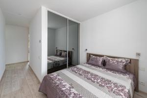 a bedroom with a large bed and a mirror at Serene Nemunas River View apartment near McDonald by Polo Apartments in Kaunas