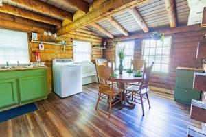 a kitchen with a table and a refrigerator at Genuine log cabin minutes away from Chattanooga's top attractions in Chattanooga