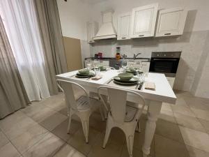a kitchen with a white table with chairs and wine glasses at Antica Residenza Colle in Nocera Umbra