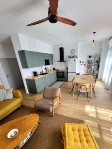 a living room with a ceiling fan and a kitchen at 3 pièces au centre-ville in Sète