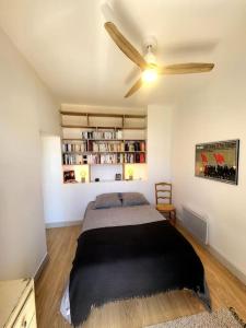 a bedroom with a bed and a ceiling fan at 3 pièces au centre-ville in Sète