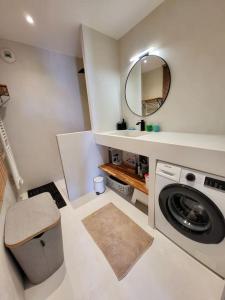 a bathroom with a washing machine and a mirror at 3 pièces au centre-ville in Sète