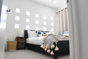 a bedroom with a black and white bed and a window at Live like a local In The Heart of Moffat Beach in Caloundra