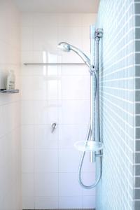 a shower in a white tiled bathroom at Live like a local In The Heart of Moffat Beach in Caloundra