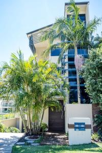 a building with palm trees in front of it at Live like a local In The Heart of Moffat Beach in Caloundra