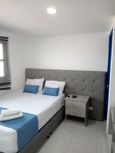 a bedroom with a large bed with blue pillows at Cozzy studio inside walled city & historic center in Cartagena de Indias