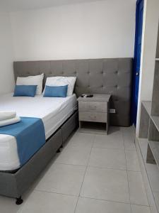 a bedroom with a bed with blue pillows and a table at Cozzy studio inside walled city & historic center in Cartagena de Indias