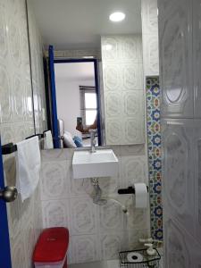 a bathroom with a sink and a toilet and a mirror at Cozzy studio inside walled city & historic center in Cartagena de Indias