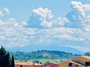 einen wolkigen Himmel mit einem Berg in der Ferne in der Unterkunft Way2Rome Apartments in Rignano Flaminio