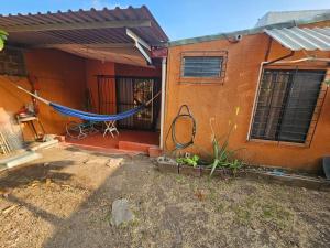 a house with a hammock in front of it at Buena Vista Home in Nueva San Salvador