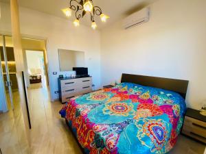 ein Schlafzimmer mit einem Bett mit einer bunten Bettdecke in der Unterkunft Way2Rome Apartments in Rignano Flaminio