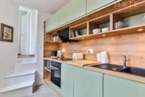 eine Küche mit Holzschränken und einem Waschbecken in der Unterkunft Maison au pied de la plage in Les Sables-dʼOlonne