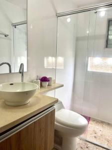 La salle de bains blanche est pourvue d'un lavabo et de toilettes. dans l'établissement Apartamento Zainos Villavicencio, à Villavicencio
