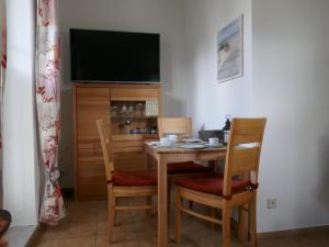 une table à manger avec deux chaises et une télévision dans l'établissement Appartement 119, à Dierhagen