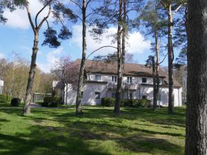 une maison blanche avec des arbres devant dans l'établissement Appartement 119, à Dierhagen 3 autres photos