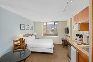 een hotelkamer met een bed en een keuken bij Cascade Lodge in Whistler