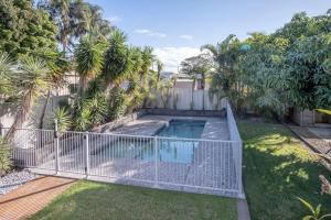 a fence around a swimming pool in a yard at Moffat Beach, Large families & friends unite here! in Caloundra