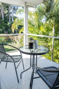 a glass table and two chairs on a porch at Moffat Beach, Large families & friends unite here! in Caloundra