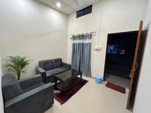 uma sala de estar com um sofá e uma televisão em Travrest Homes em Guwahati