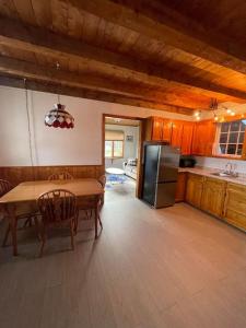 a kitchen with a table and a refrigerator at Ardan Cottage in Ingonish in Ingonish Beach