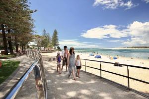 a group of people walking on the beach at Spacious Apartment, Walk To Kings Beach in Caloundra
