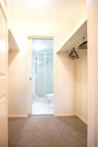 an empty bathroom with a toilet and a shower at Spacious Apartment, Walk To Kings Beach in Caloundra