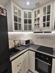 a kitchen with white cabinets and a microwave at Czarny Jeleń in Zakopane +32 photos