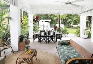 a patio with a couch and a table and chairs at Buderim Rainforest Retreat - 10 mins to Mooloolaba in Buderim
