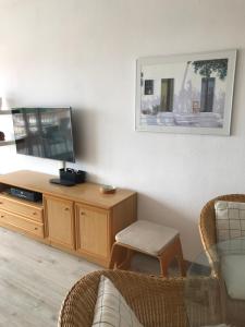 sala de estar con TV de pantalla plana y silla en Narciso views, en Vilassar de Mar