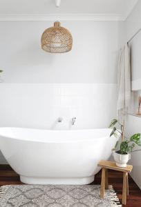 a white bath tub in a bathroom with a potted plant at Buderim Rainforest Retreat - 10 mins to Mooloolaba in Buderim