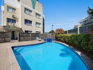 a large blue swimming pool in front of a building at Kings Beach Oceanfront Apartment With Pool in Caloundra
