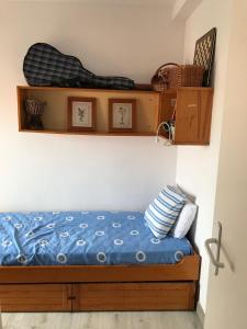 1 dormitorio con 1 cama con sábanas azules y estanterías de madera en Narciso views, en Vilassar de Mar