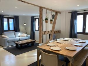 ein Wohnzimmer mit einem Tisch und einem Sofa in der Unterkunft L’atelier du bricoleur in Marckolsheim