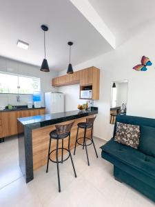 eine Küche und ein Wohnzimmer mit einer Theke und Stühlen in der Unterkunft Village Mariah in Coroa Vermelha