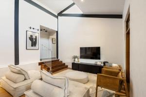 a living room with a couch and a tv at The Noosa Ranch- Where Nature meets Luxury in Tinbeerwah