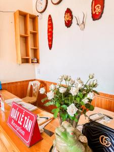 einen Tisch mit einer Blumenvase und einem Schild in der Unterkunft Lake View Ninh Binh in Tam Ðiệp