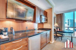 a kitchen with a sink and a dining room with a table at MGM Signature 15-603 Strip View Jacuzzi Studio in Las Vegas