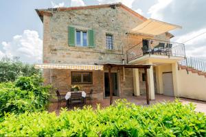 Una casa con una mesa y sillas delante de ella. en Agriturismo Brocca, en Tuoro sul Trasimeno