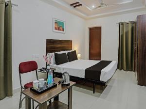 a hotel room with a bed and a table and a desk at Hotel White Ridge Near Kondapur in Kondapur