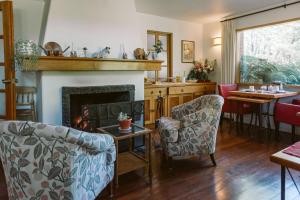 a living room with a fireplace and a table and chairs at Hotel Posada del Río - Parque Metreñehue in Pucón